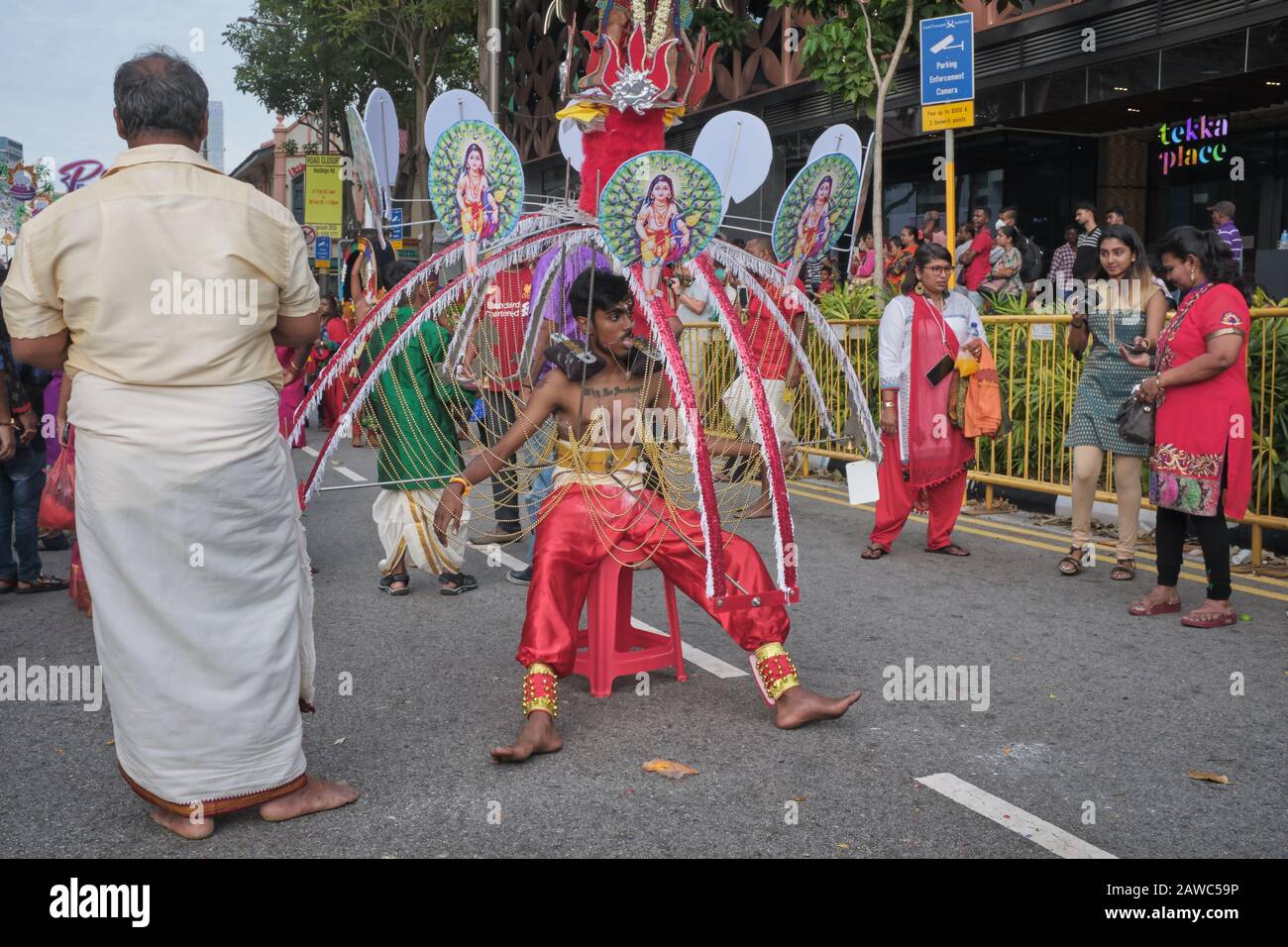 Pour le festival hindou de Thaipusam, un participant portant un Kavadi en l'honneur de dieu Murugan siège sur une chaise pour se remettre de l'épuisement; Singapour Banque D'Images