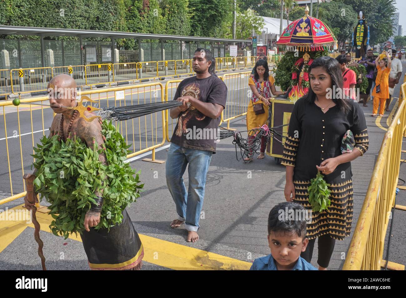 Pour le festival hindou de Thaipusam, un participant est accroché à des cordes, par lesquelles il tire un petit char festif; Little India, Singapour Banque D'Images