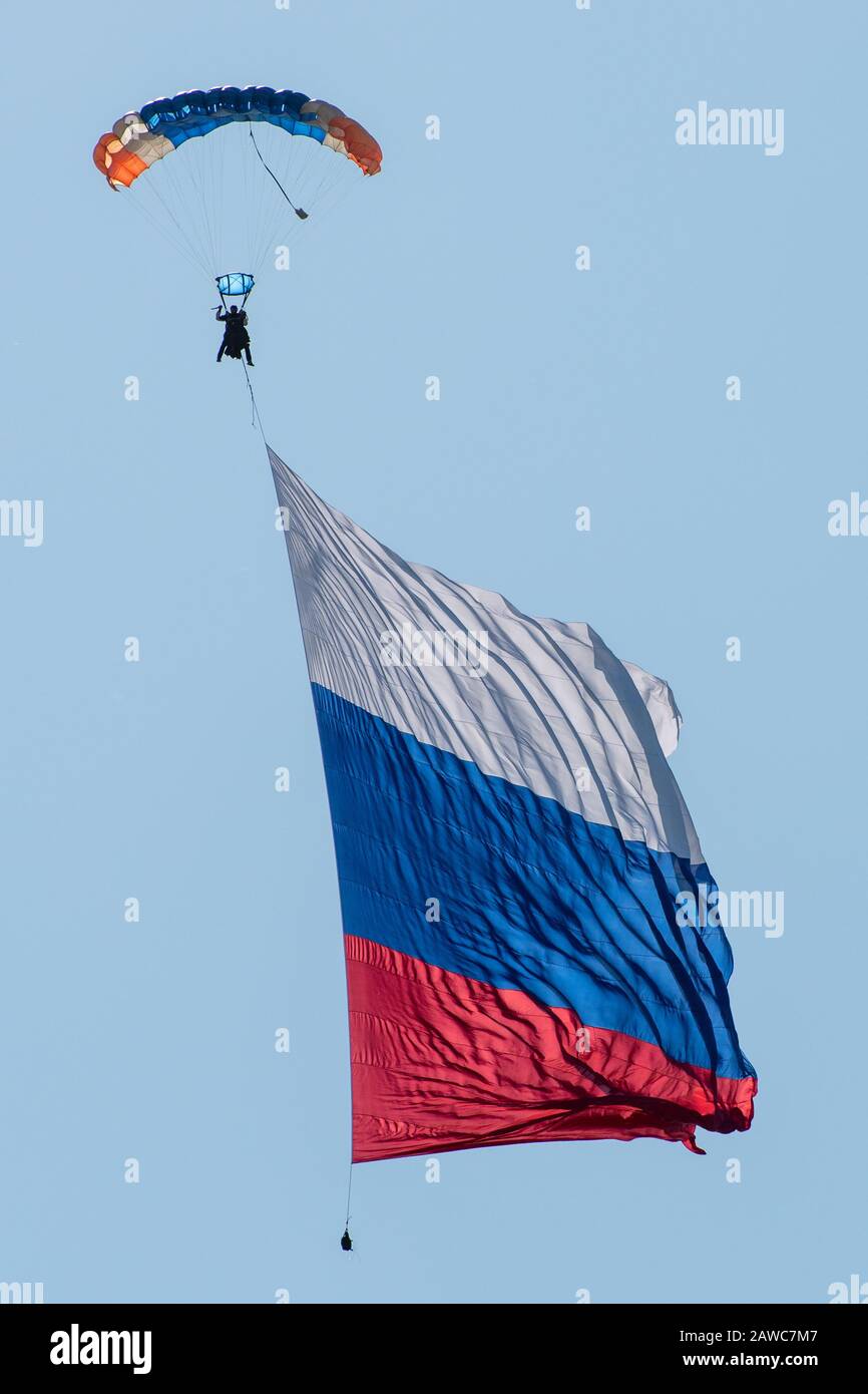 Skydiver dans le ciel avec un drapeau géant de la Russie contre le ciel bleu. Banque D'Images