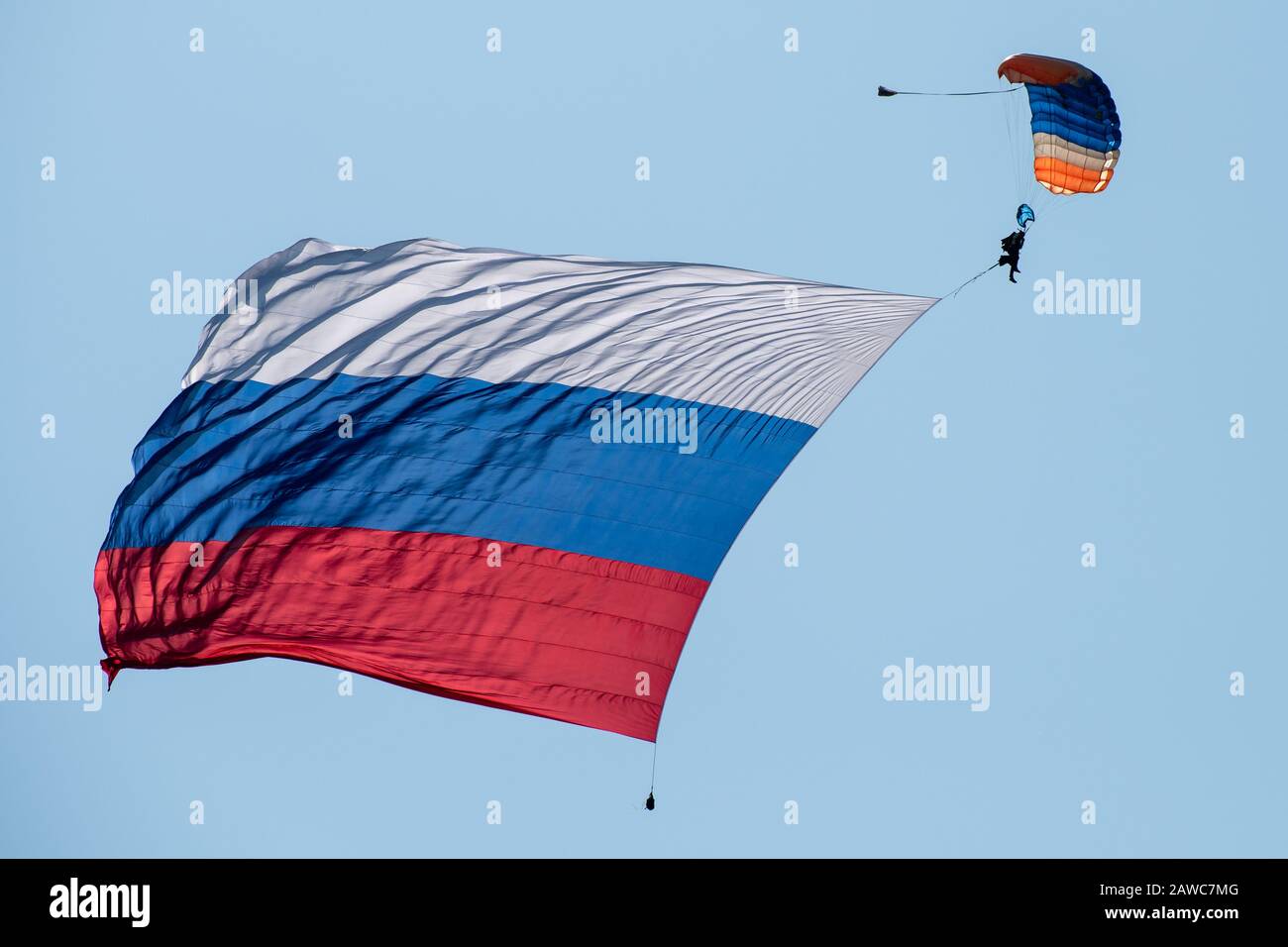 Skydiver dans le ciel avec un drapeau géant de la Russie contre le ciel bleu. Banque D'Images