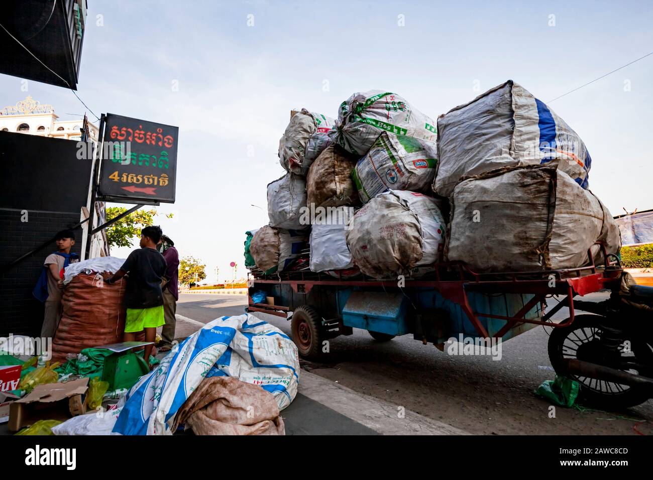 Les jeunes hommes asiatiques sont des sacs de pesage remplis de boîtes en aluminium recyclables avant le transport vers des intermédiaires de recyclage à Kampong Cham, au Cambodge. Banque D'Images