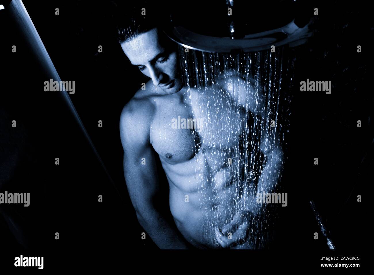 Portrait sexy de l'homme nu beau avec sixpack abs et pecs regardant  réfléchie sous une douche de pluie Photo Stock - Alamy