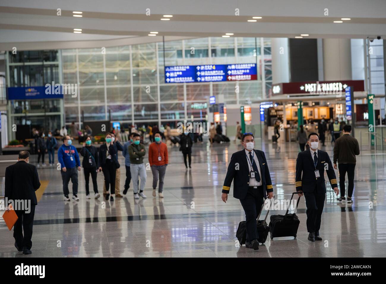 Les pilotes de compagnies aériennes ont vu porter des masques chirurgicaux comme une mesure de protection contre le coronavirus mortel à l'aéroport international de Hong Kong.Des Centaines de vols entre les villes chinoises continentales et Hong Kong annulent comme la mesure de quarantaine obligatoire de 14 jours que les voyageurs devront rester à la maison ou à l'hôtel pour être mis en quarantaine prend effet. Banque D'Images