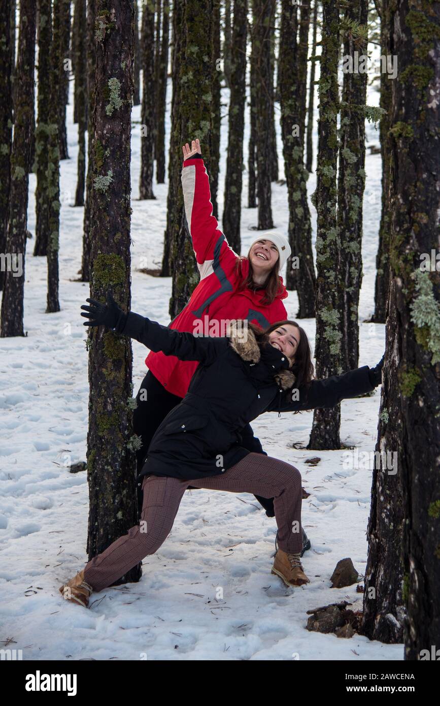 Jeunes filles adolescentes heureuses et belles vêtues de vêtements d'hiver debout et discutant sur neige en hiver. Montagnes de Troodos à Chypre Banque D'Images