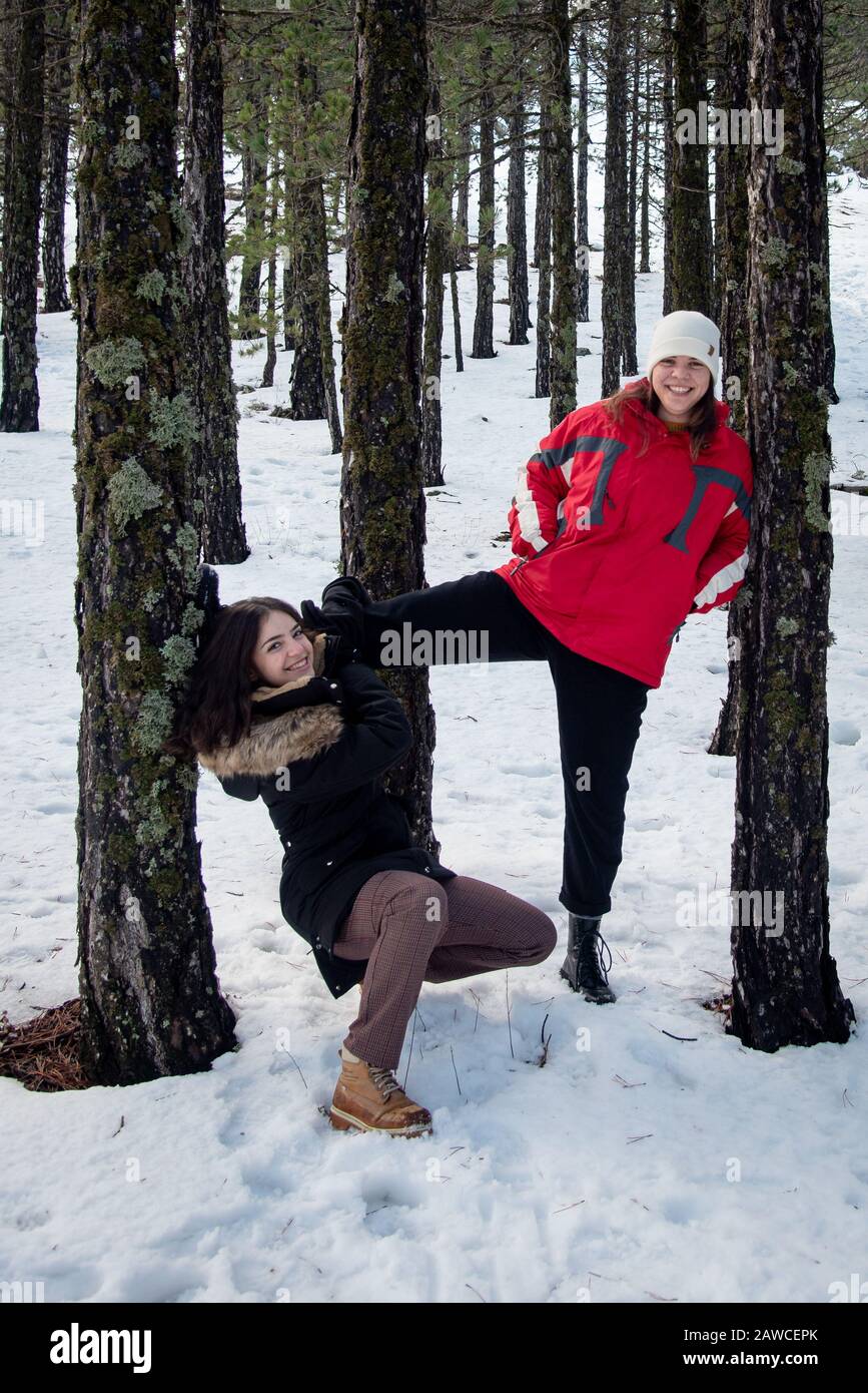 Jeunes filles adolescentes, belles et heureuse, vêtues de vêtements d'hiver jouant à des jeux sur neige en hiver. Montagnes de Troodos à Chypre Banque D'Images