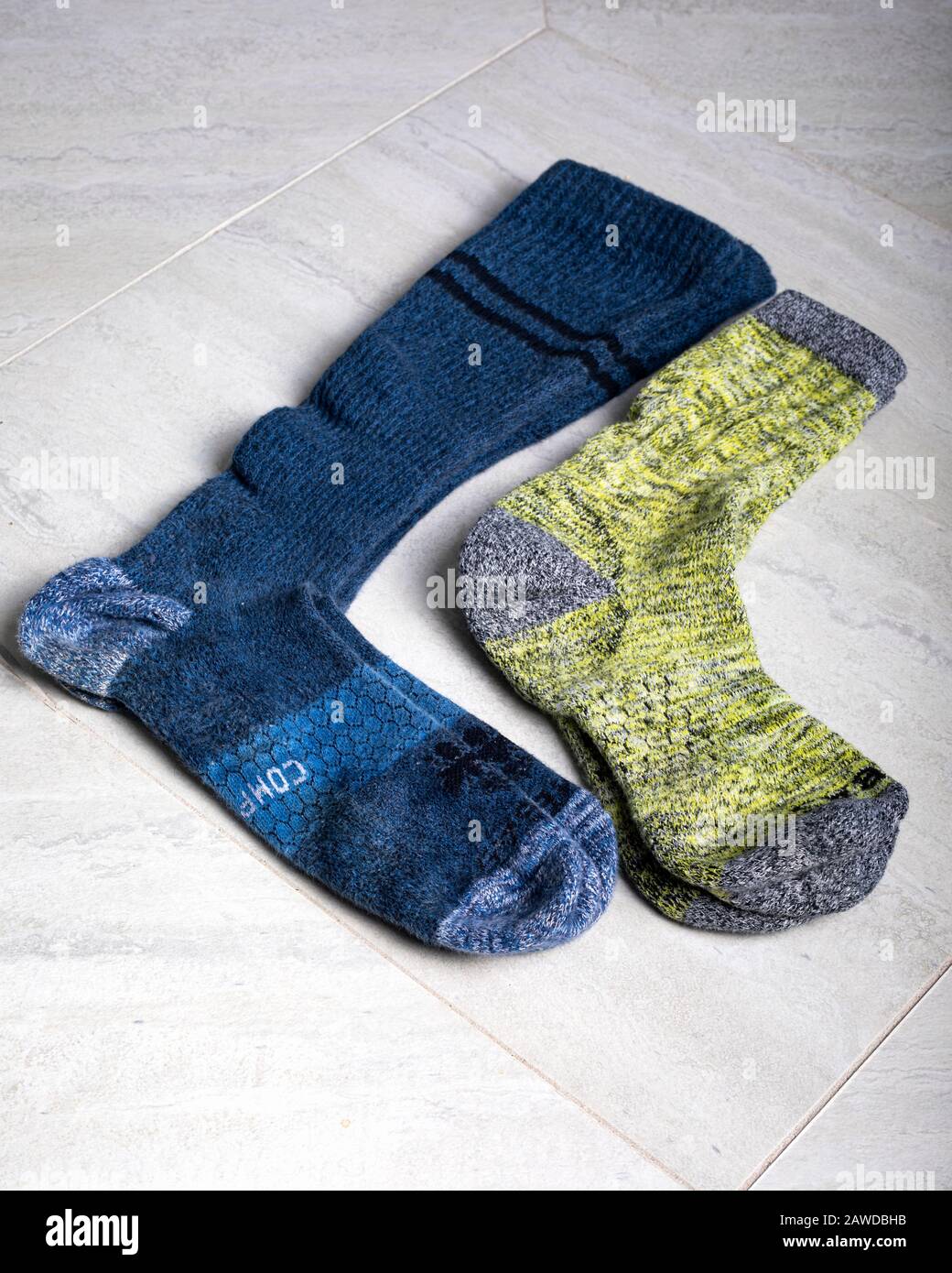Chaussettes de mollet jaunes Bombas illustrées à côté de chaussettes de compression bleues Bombas, montrant une différence de longueur. Banque D'Images