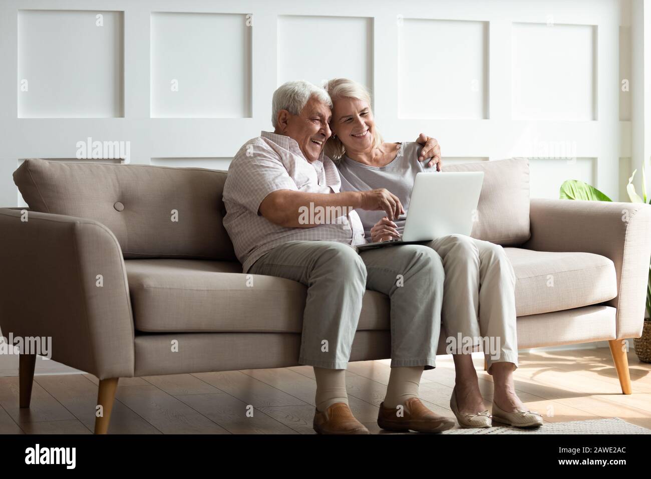 Les couples adultes modernes ont du plaisir à utiliser leur ordinateur portable à la maison Banque D'Images