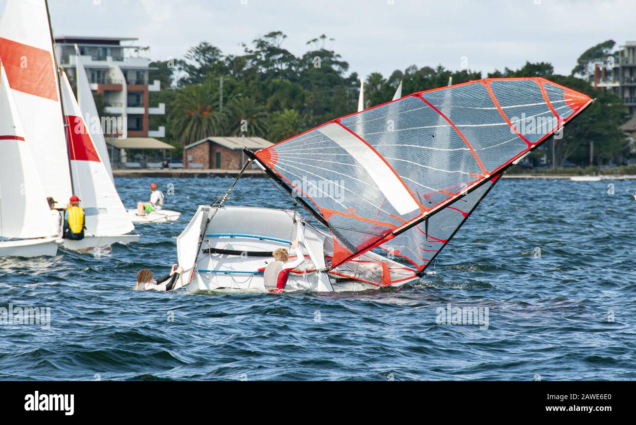 Les enfants qui font de la voile se remontent dans un voilier de taille moyenne. Les enfants naviguent dans des dinghies pour s'amuser et en compétition. Des marins juniors en course sur s Banque D'Images