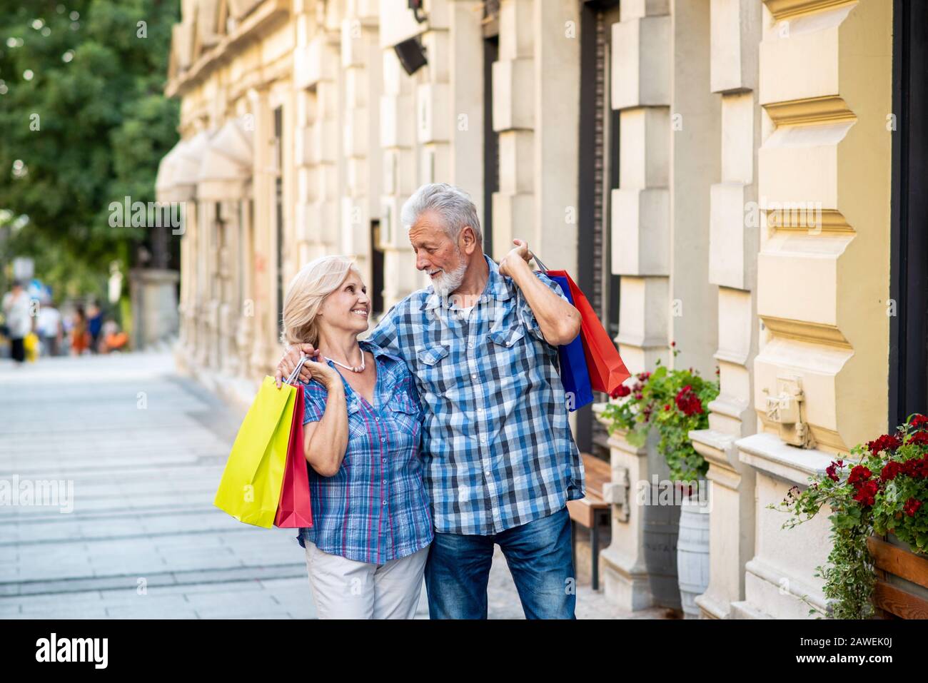 Happy senior couple with shopping bags. Senior couple hugging Banque D'Images