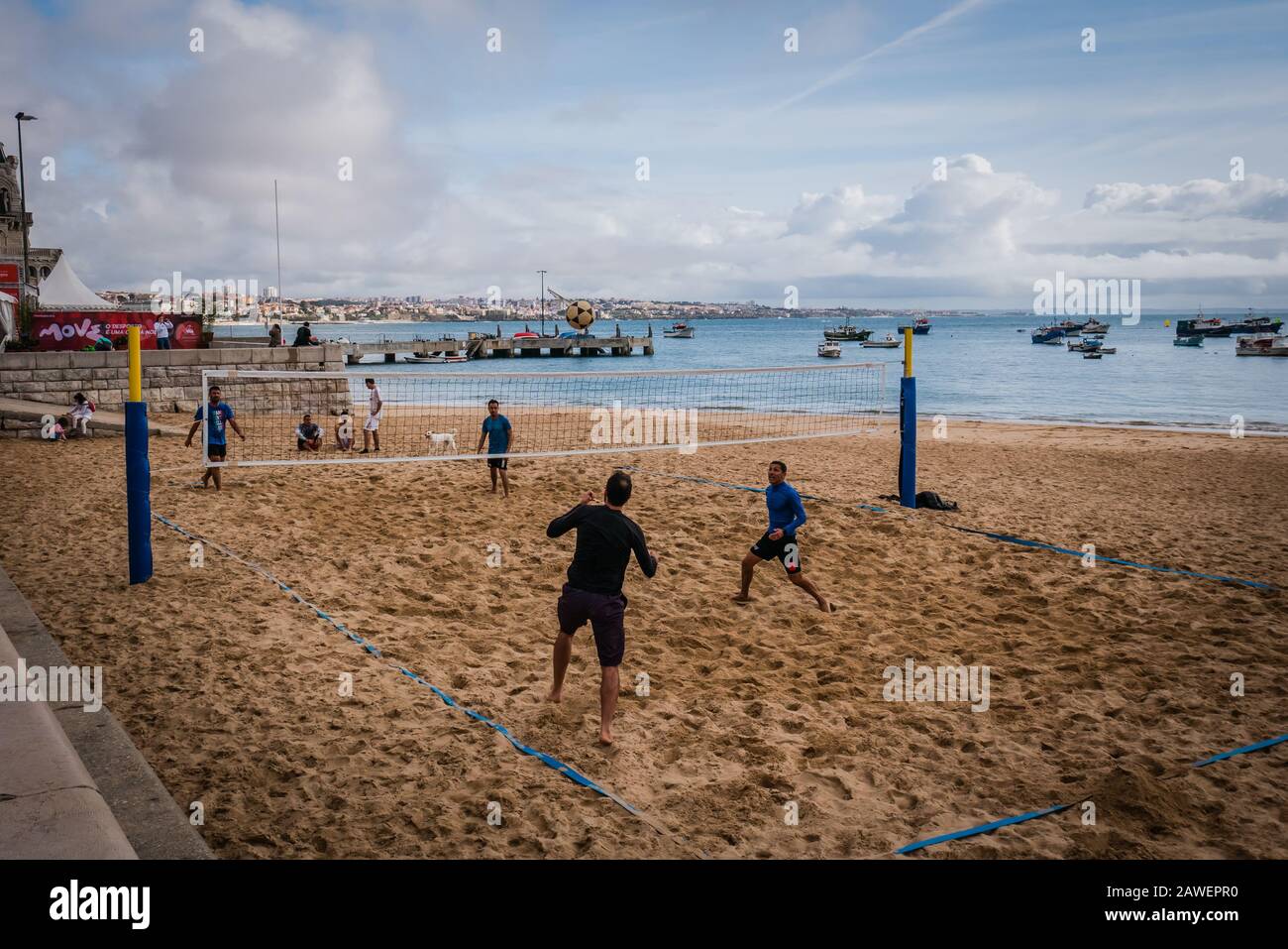 Les hommes jouant à la marche de la plage Praia da Ribeira, la plage principale de Cascais, qui fait face à la place centrale des villes et surplombe le port de pêche Banque D'Images