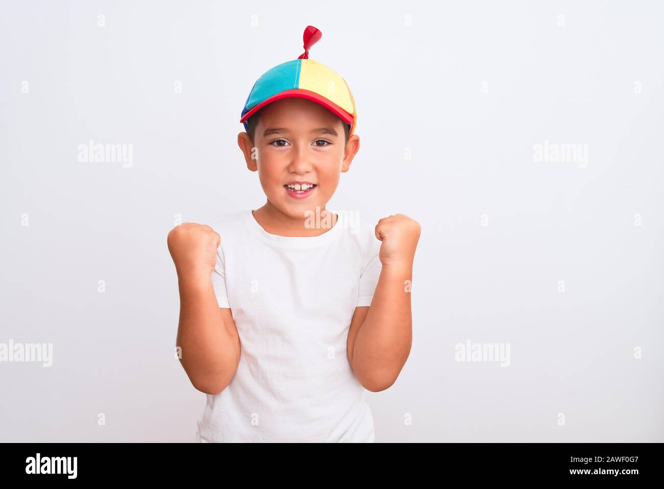 Beau garçon de gamin portant une casquette colorée fanny avec hélice sur  fond blanc isolé célébrant surprise et étonné de succès avec des rais  d'armes Photo Stock - Alamy