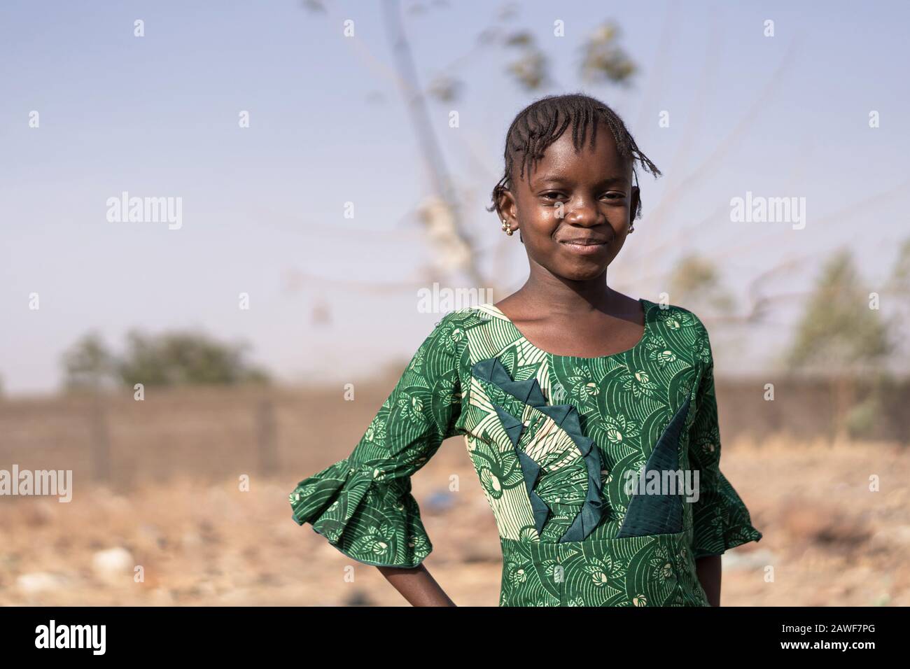 La beauté africaine se tient Fièrement dans la savane du sud du Mali avec le sourire mignon Banque D'Images