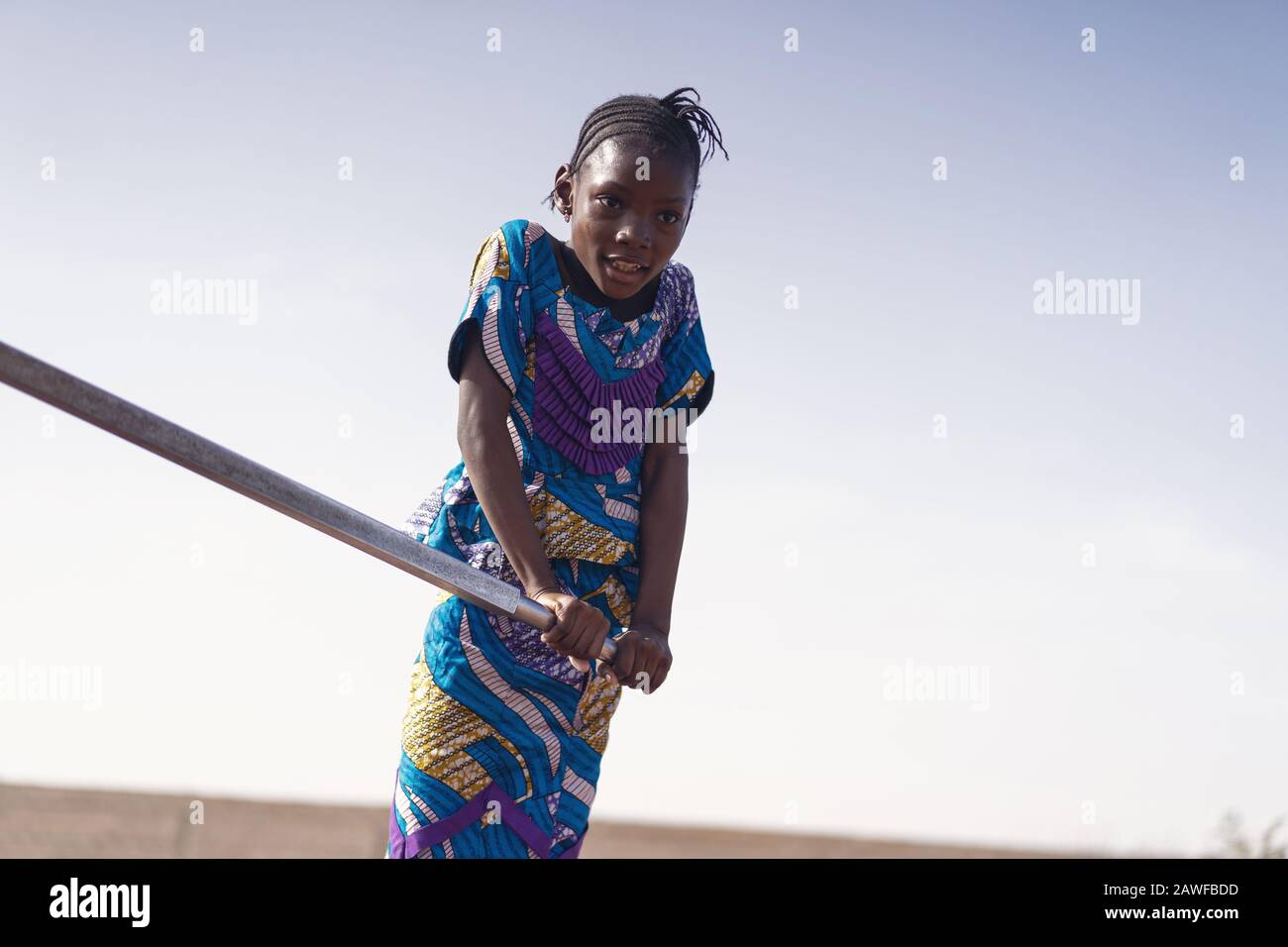 Joyeuse ethnicité africaine jeune femme Transportant de l'eau pure à Bamako Banque D'Images