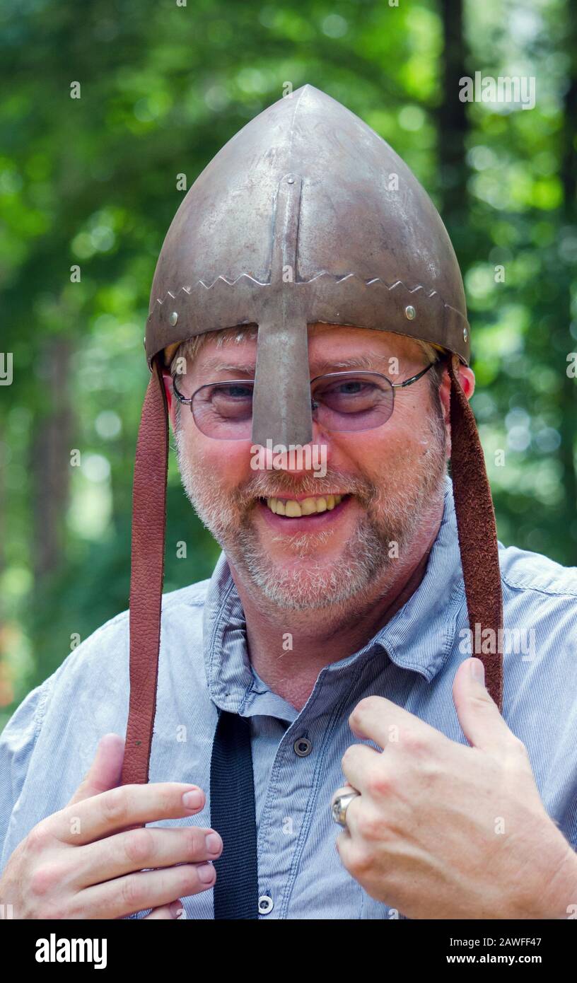 Un homme moderne de jour pose portant un casque médiéval appelé cervellière, casque primaire pour les croisés à la cravate Banque D'Images Un homme moderne de jour pose portant un casque médiéval appelé cervellière, casque primaire pour les croisés à la cravate Banque D'Images