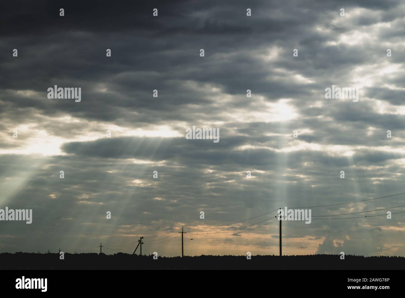 La lumière du soleil brille à travers le ciel nuageux. Ciel orageux avec sunbeam. Temps couvert. Ligne Horizon Banque D'Images