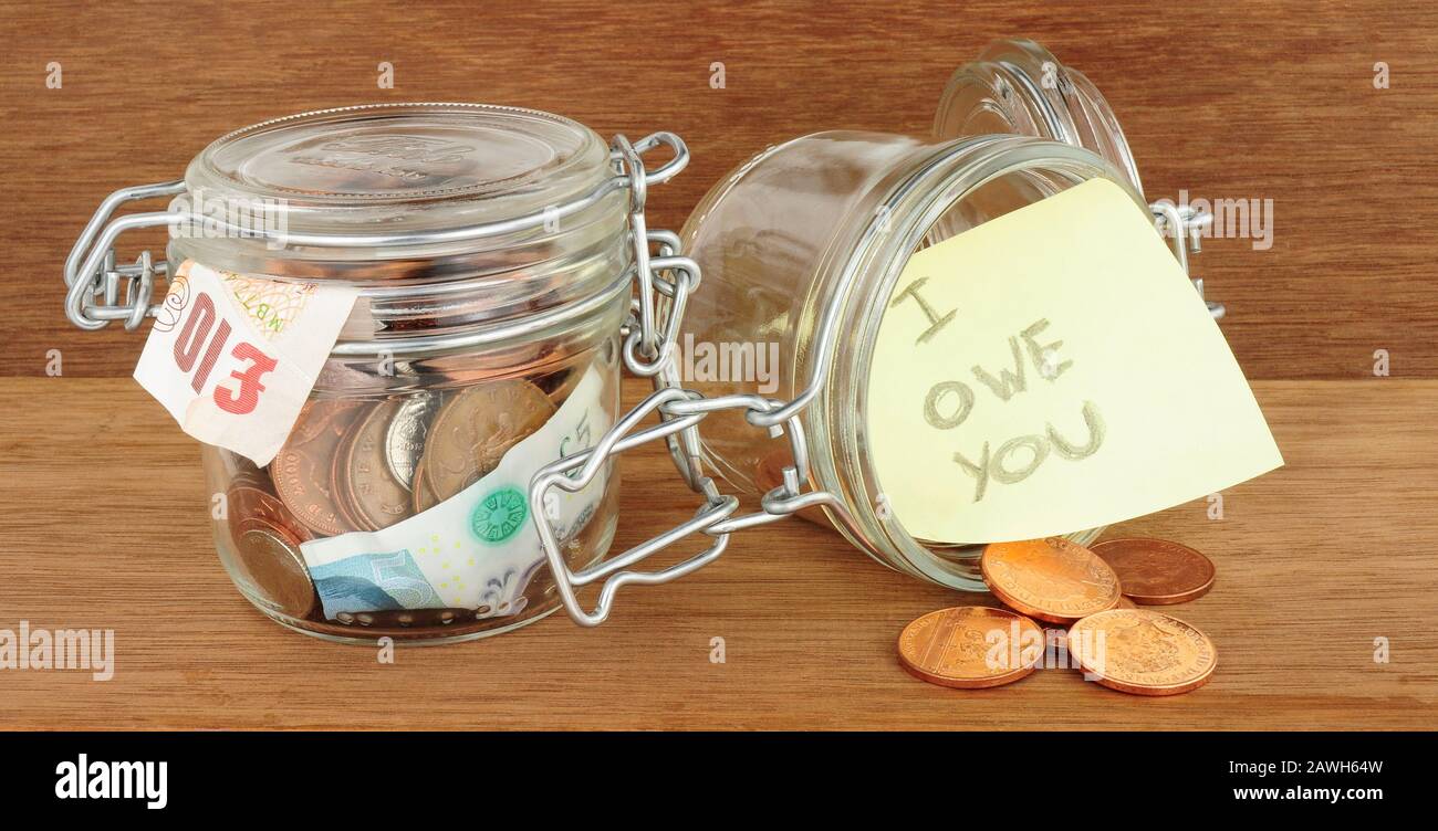 Pots en verre remplis d'économies d'argent sur un fond de bois Banque D'Images
