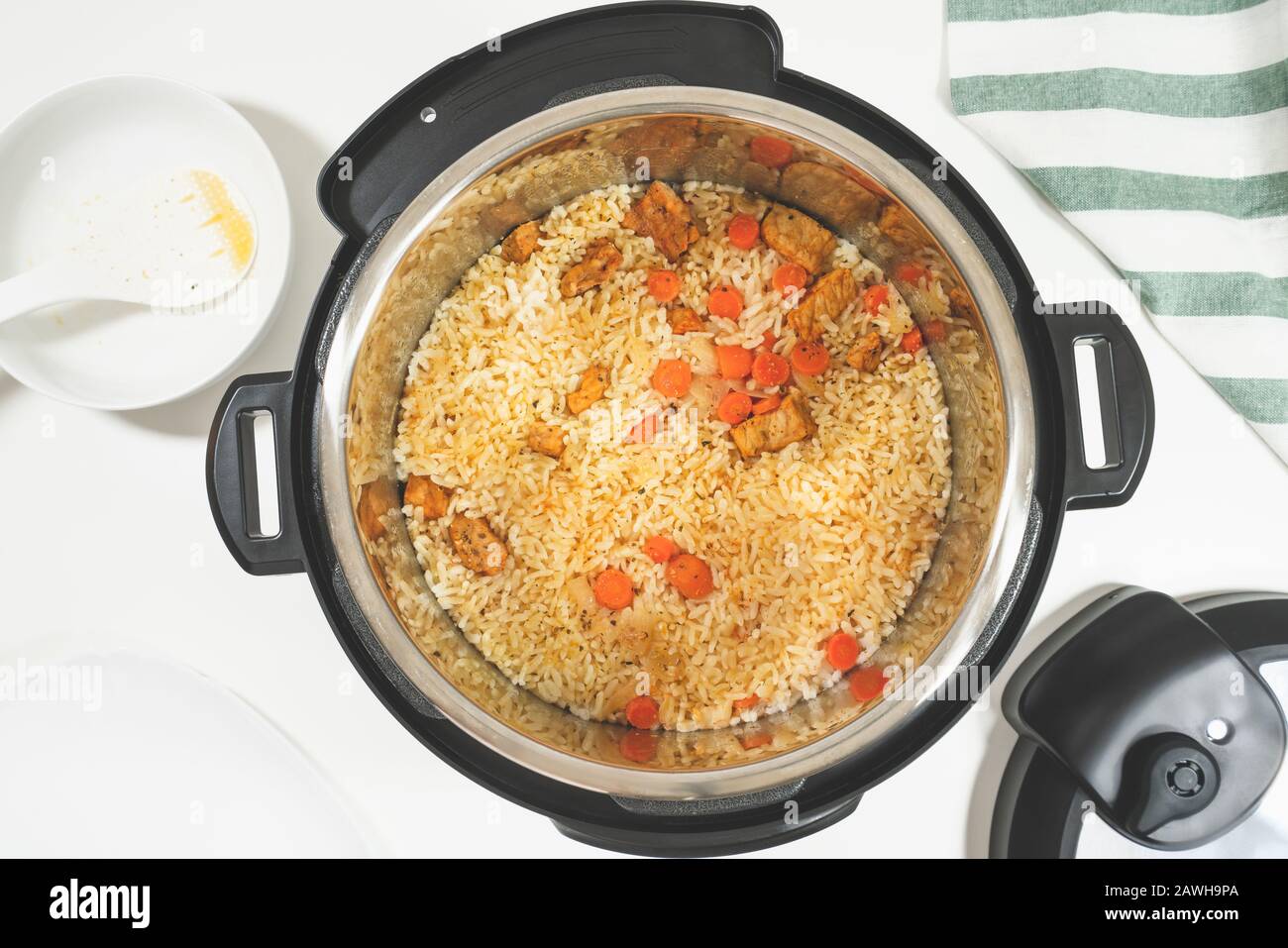 Riz à base de viande et légumes préparés dans plusieurs cuisinières, gros plan sur fond blanc, vue du dessus Banque D'Images