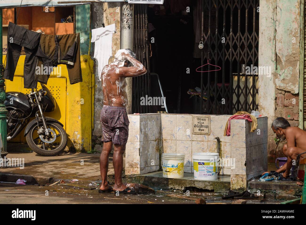 L'homme se laver de la pompe dans la rue à Kolkata. Inde Banque D'Images