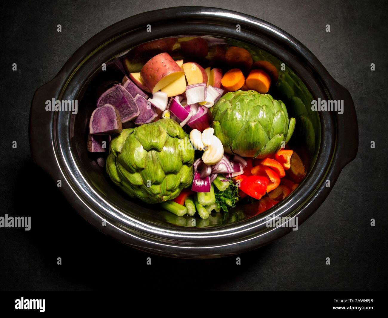 Grande casserole noire avec légumes hachés sur elle prête à cuire. Cuiseur lent, pot à récolte. Concept sain. Banque D'Images