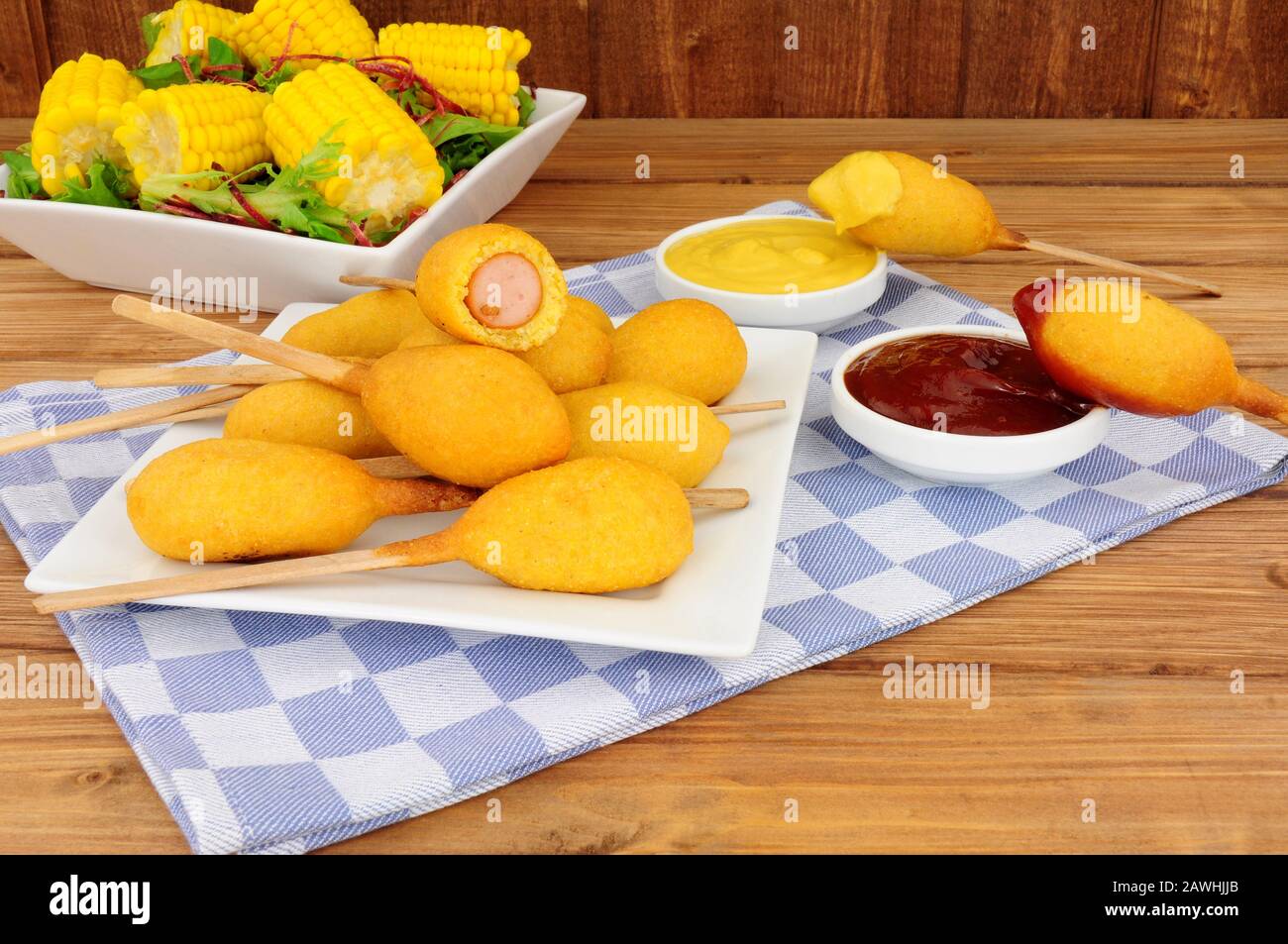 Petits corniches de fête sur des bâtonnets de bois avec des sauces à la moutarde et à la tomate Banque D'Images
