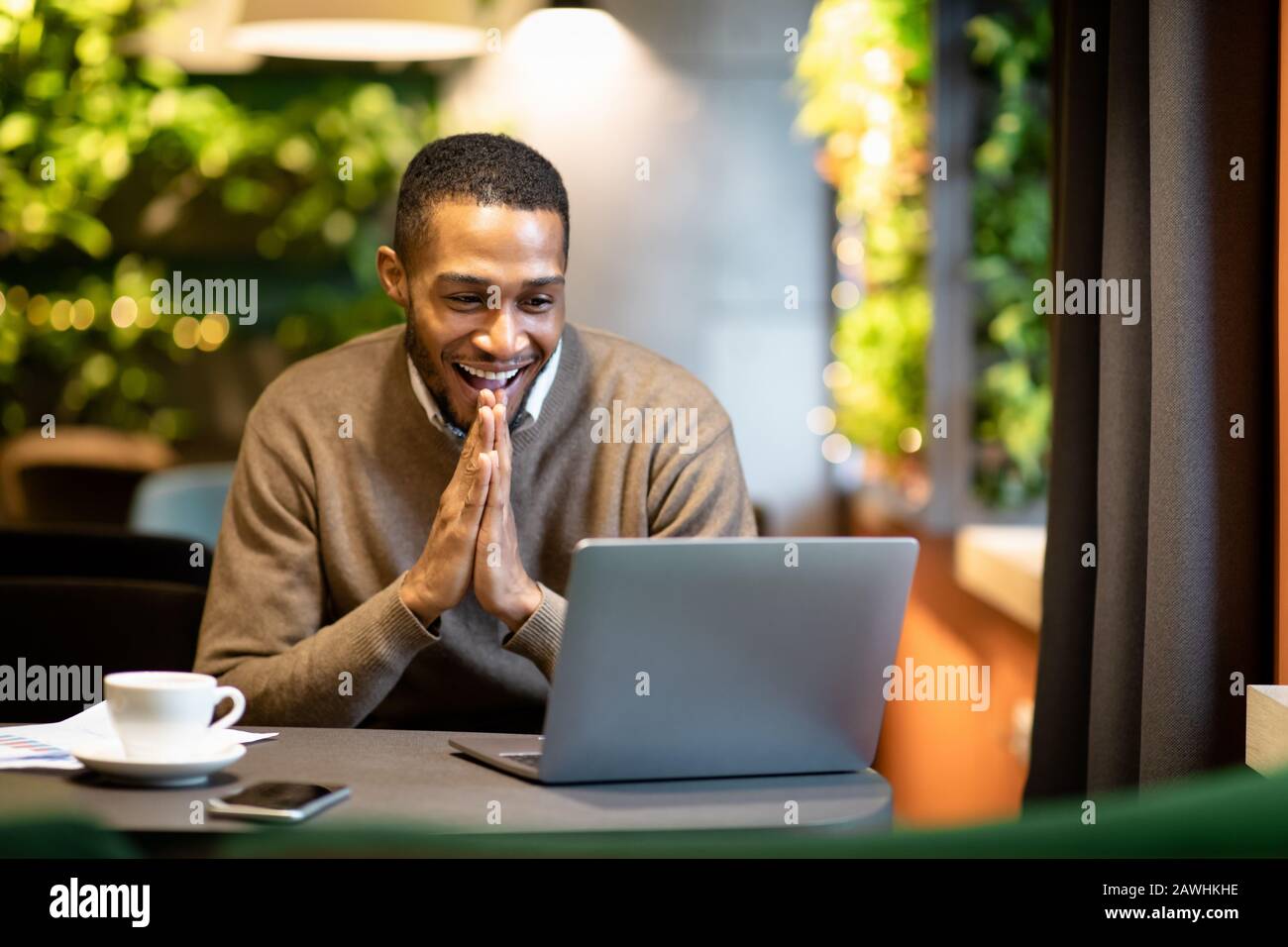 Afro homme d'affaires utilisant un ordinateur portable assis au café Banque D'Images