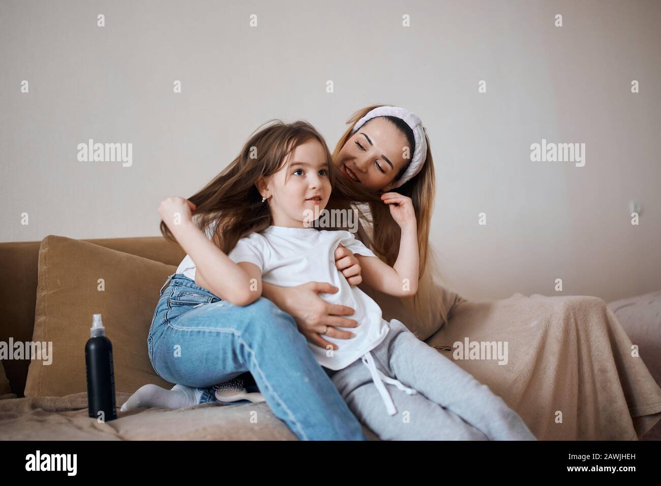 jeune blonde gaie et son adorable enfant assis sur le lit, parler, s'amuser, partager des secrets. photo de gros plan, amitié, relation Banque D'Images