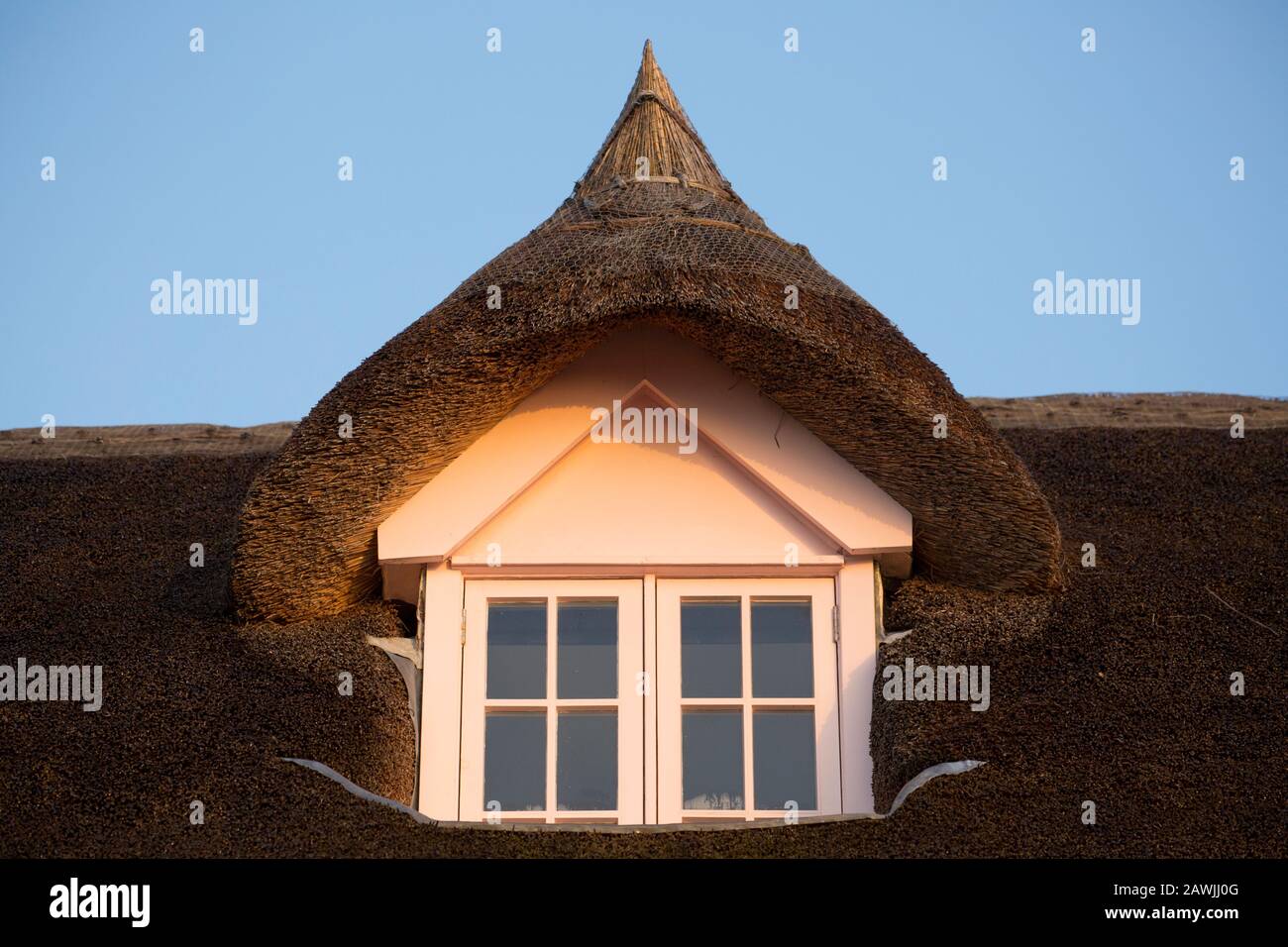 Une maison en chaume au lever du soleil en février sur le front de mer de Lyme Regis. La région est populaire auprès des chasseurs de fossiles et de nombreuses personnes viennent visiter le famou Banque D'Images