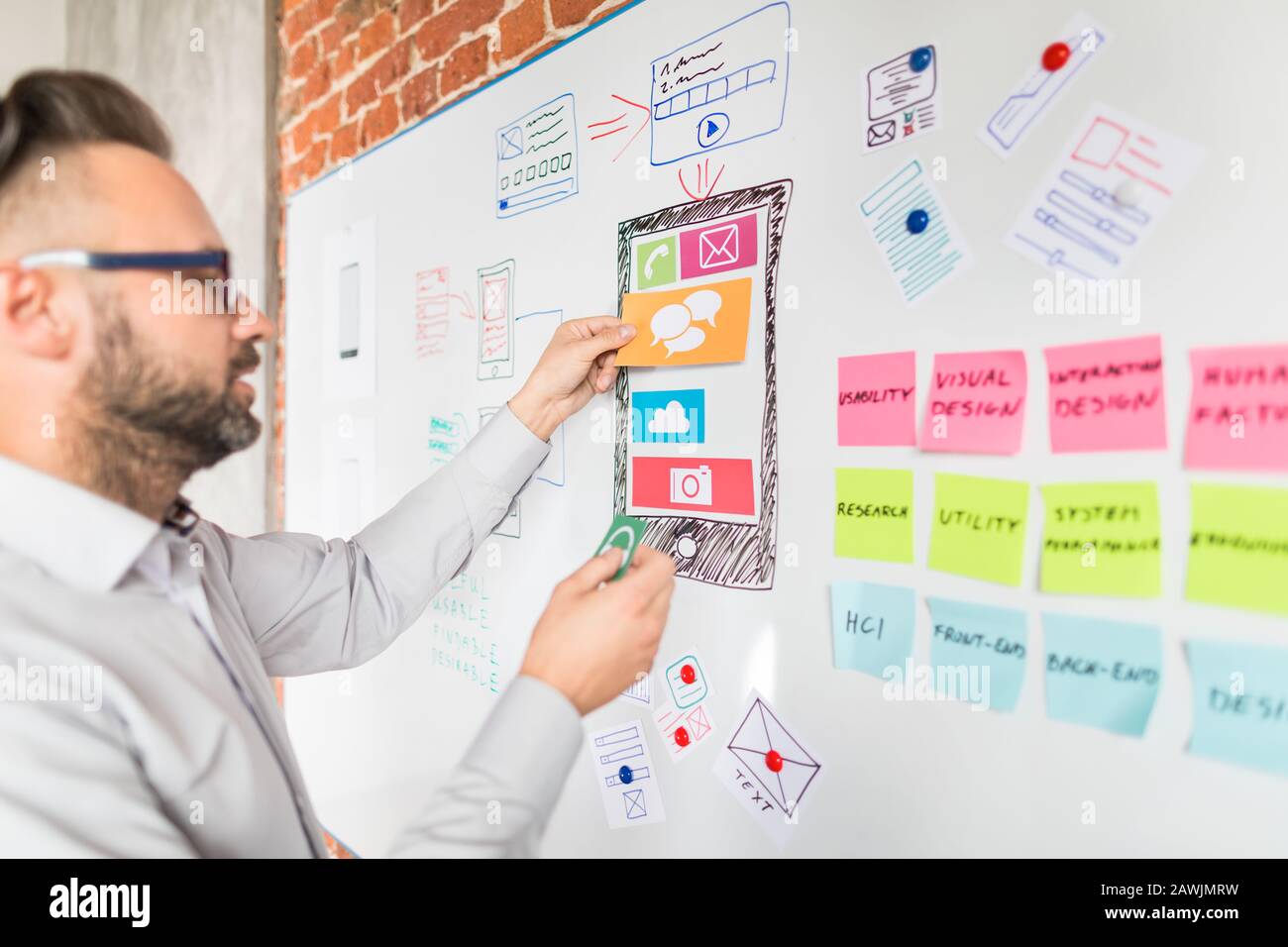 Concepteur man dessin site web ux développement d'applications et tenir le smartphone à portée de main. Concept d'expérience utilisateur. Banque D'Images