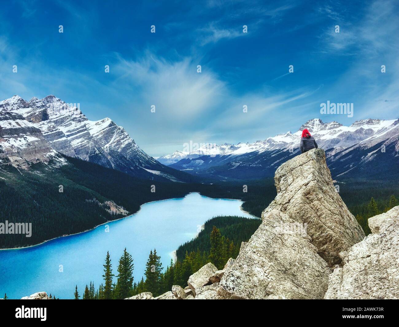 Lac Peyto, parc national Banff au Canada avec les Rocheuses canadiennes au loin, et une femme s'est assise sur un rocher au premier plan avec des cheveux roses Banque D'Images