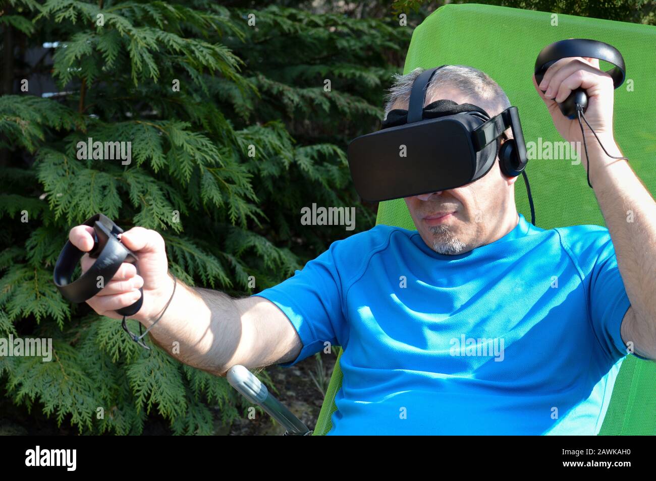 homme mûr portant des lunettes de réalité virtuelle à l'extérieur dans son jardin, l'expérience de la technologie moderne, l'utilisation de la simulation informatique Banque D'Images