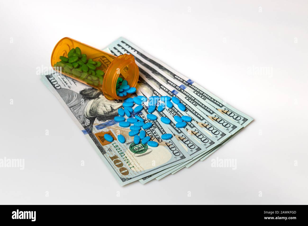 Flacon de comprimé de médicament de prescription avec facture de 100 dollars isolée sur fond blanc. Concept de hausse des coûts des médicaments, des soins médicaux, des assurances et des soins de santé Banque D'Images