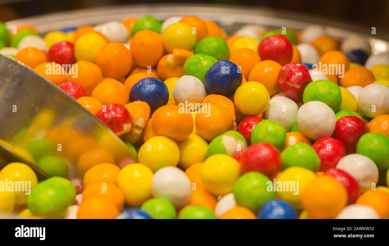 Gros plan / Macro de gommettes colorées dans un bol. Délicieuses et douces confiseries. Les couleurs sont l'orange, le jaune, le bleu, le vert, le rouge et le blanc. Banque D'Images