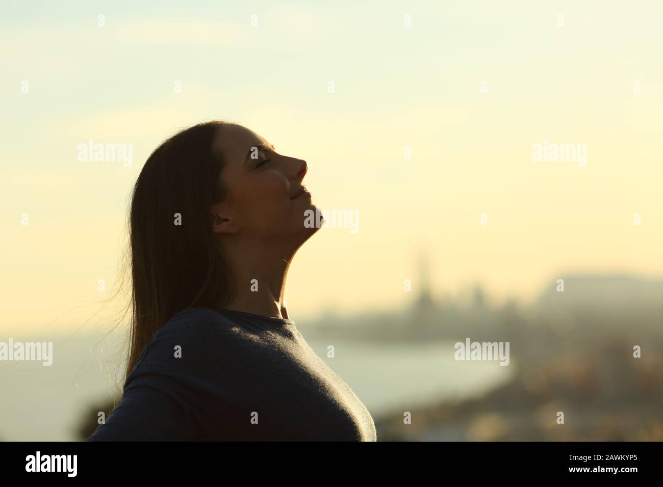 Vue latérale portrait d'une silhouette de femme respirez l'air frais au coucher du soleil Banque D'Images