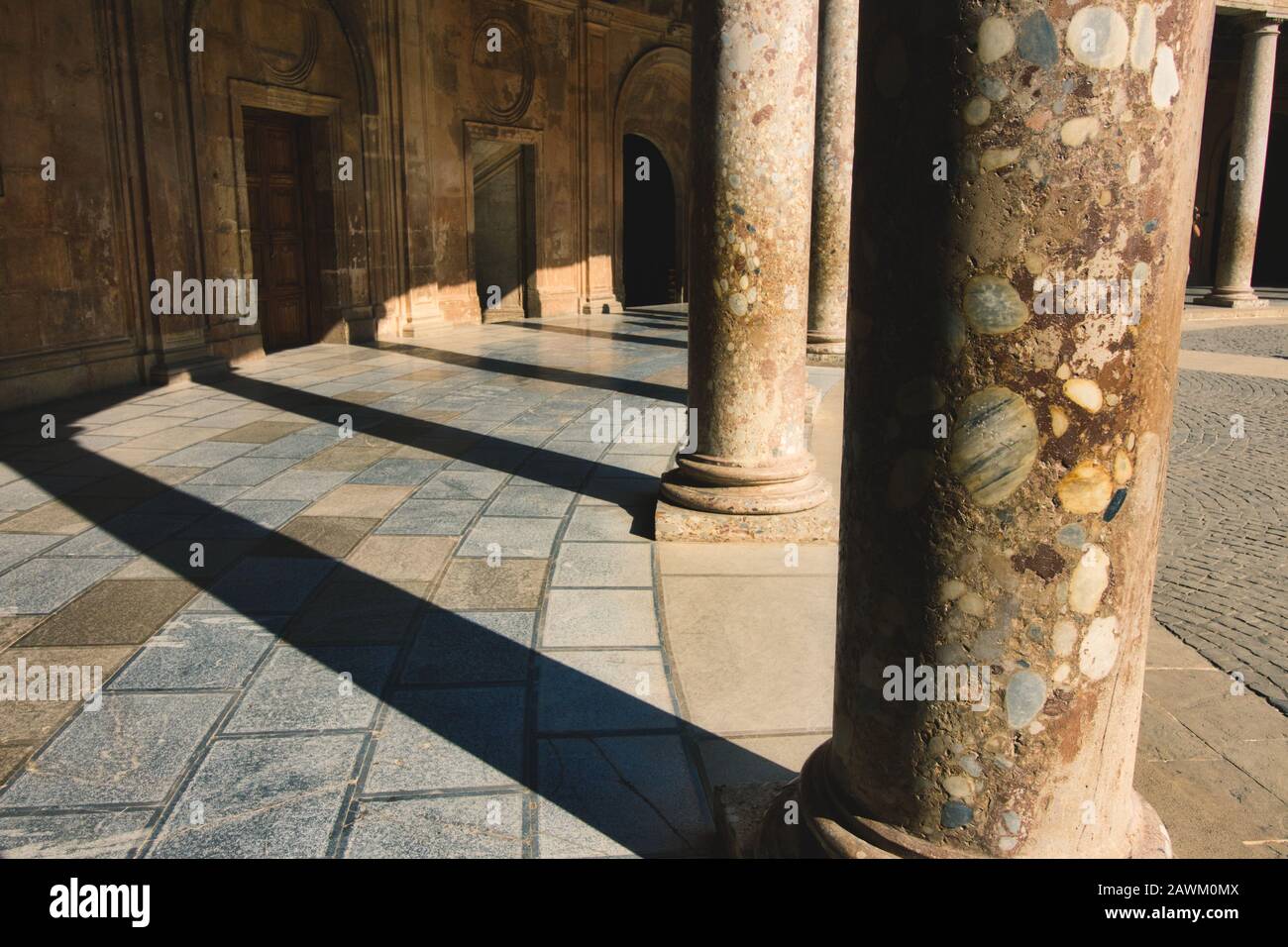 Colonnes jetant des ombres dans le Palais Charles V à l'Alhambra de Grenade, Espagne Banque D'Images