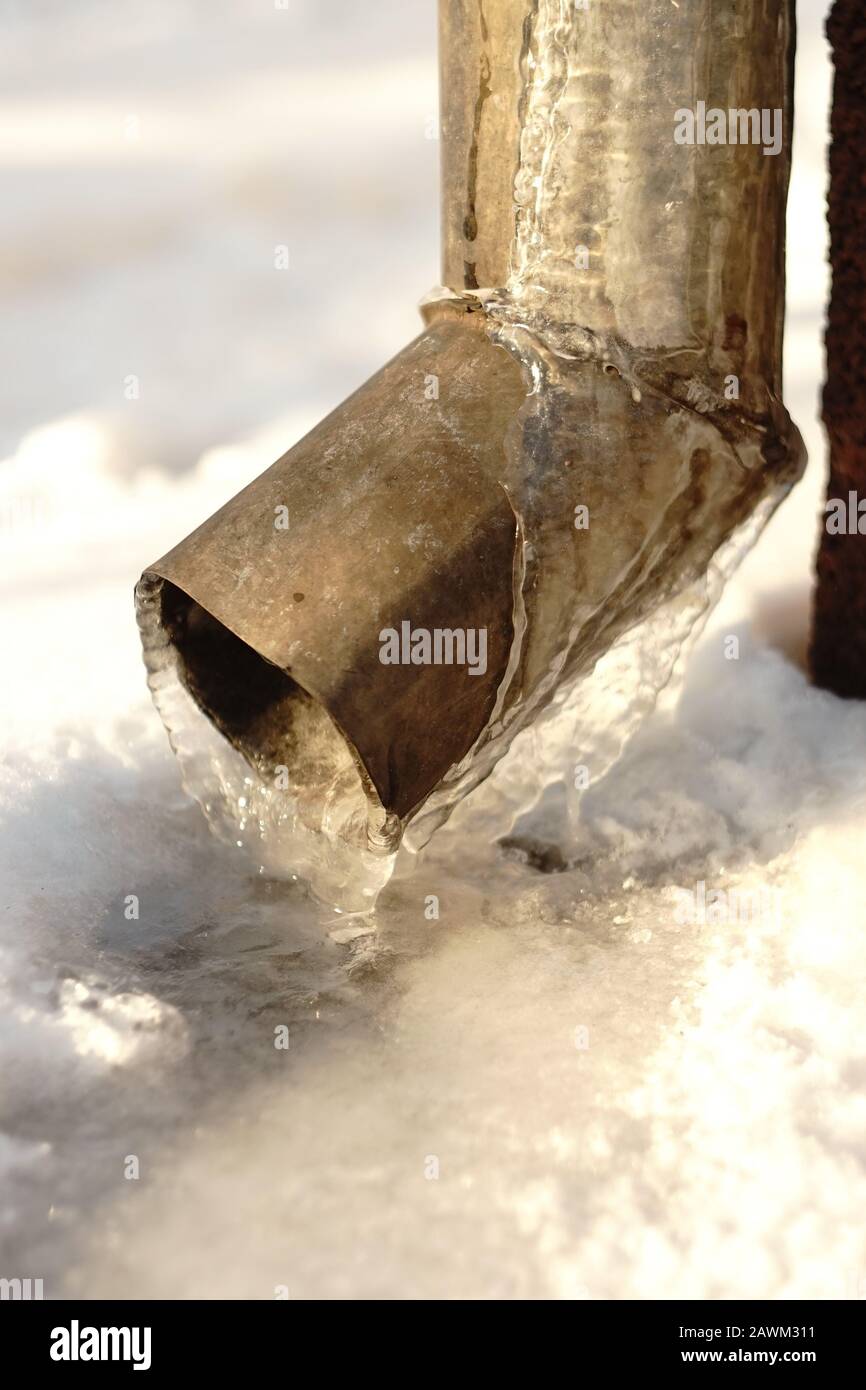 Drainpipe à l'angle de la maison couverte de glace Banque D'Images