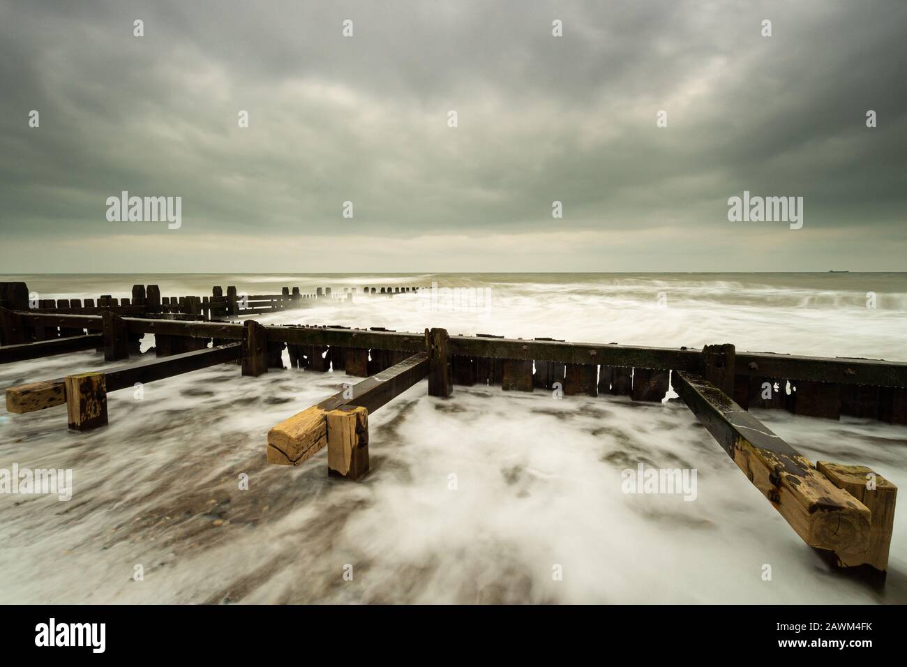 Des groynes qui sortent en mer sur la plage de Happisburg, Norfolk Banque D'Images