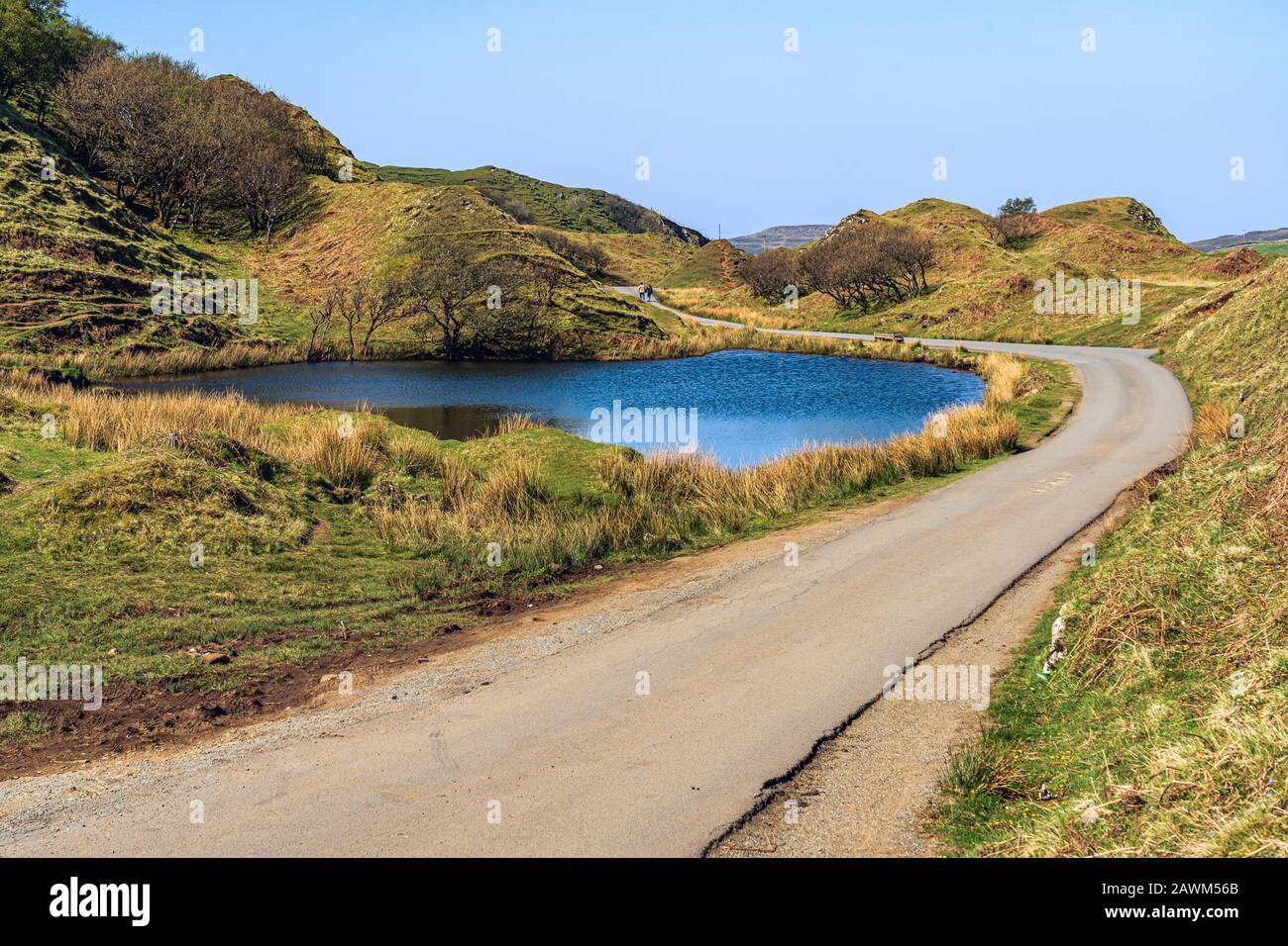 Femme avec une veste rouge debout aux Piscines Fairy de Glen Fragile sur l'île de Skye. Banque D'Images