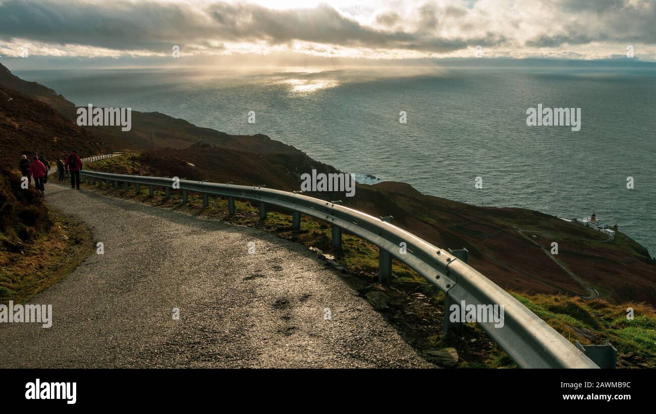 Les gens qui descendent jusqu'au Mull of Kintyre phare avec vue sur l'Irlande du Nord et l'île de Rathlin dans des conditions météorologiques spectaculaires en hiver, Scot Banque D'Images