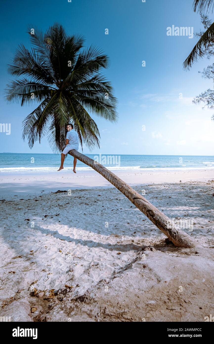 Thung Wua Laen plage Chumphon Thaïlande, hommes sur la plage par palmier penchant sur la plage blanche Banque D'Images
