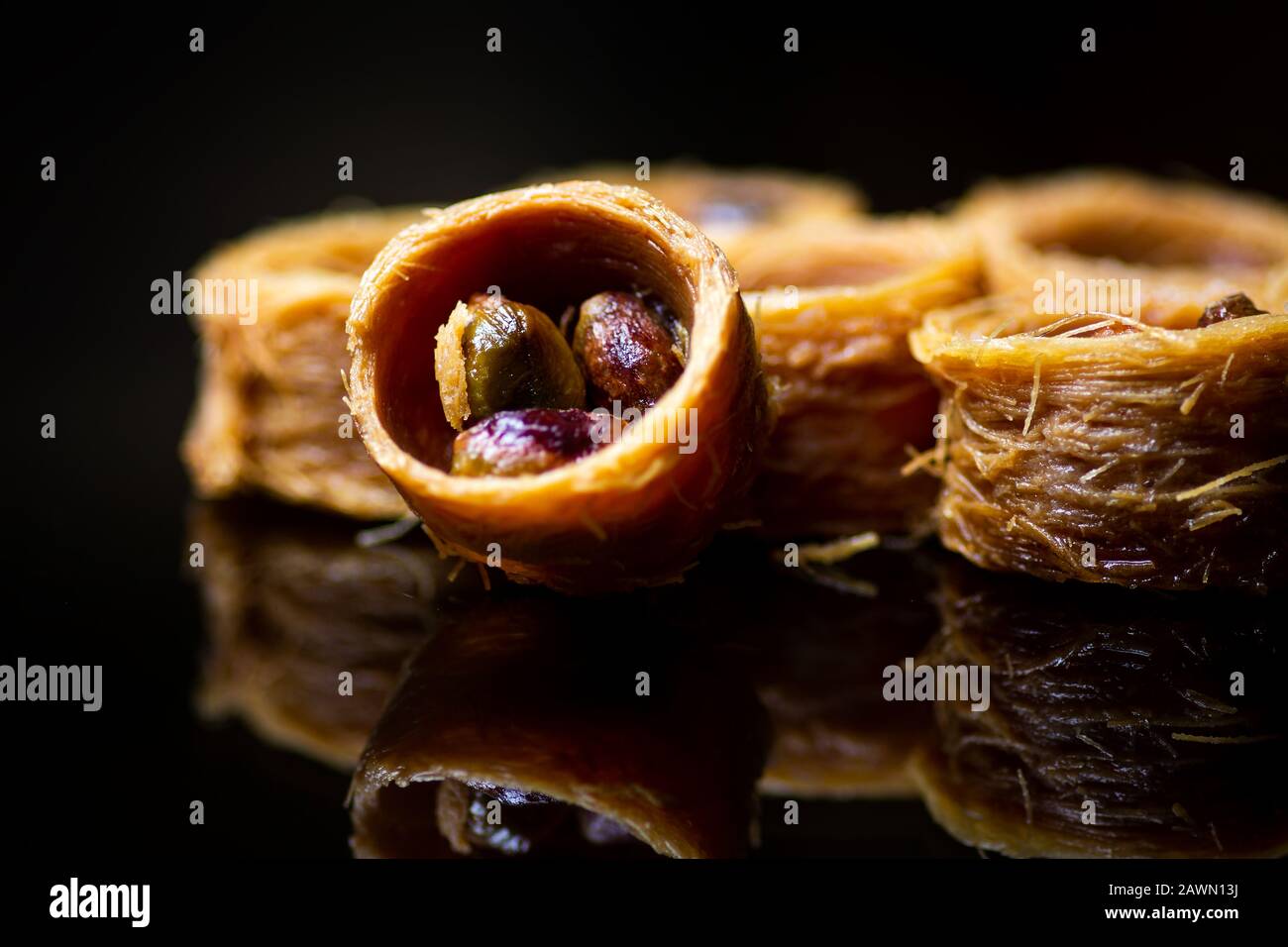 Dessert arabe avec pistache réfléchie sur fond sombre Banque D'Images