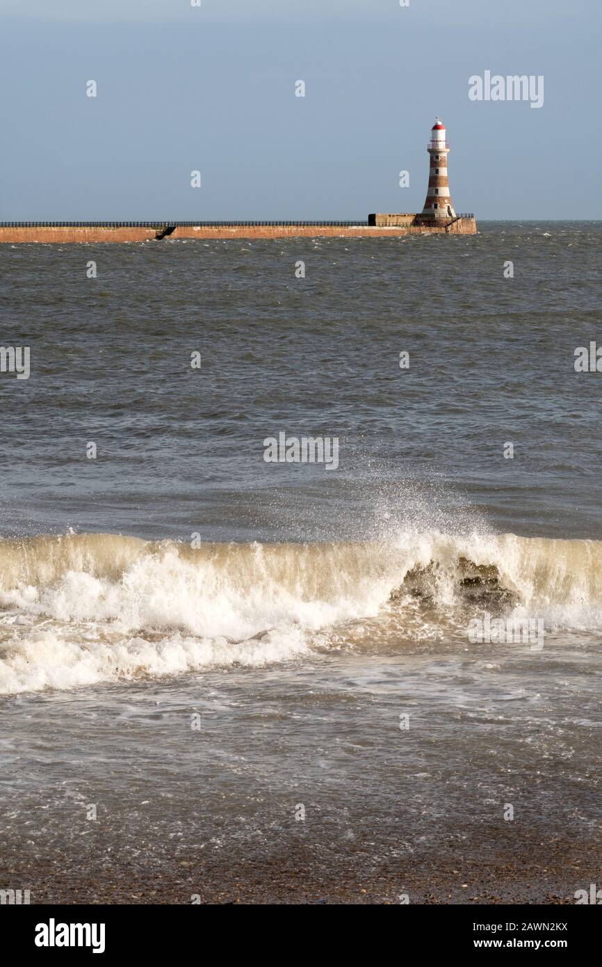 Roker North Pier et phare avec une vague de rupture au premier plan, Sunderland, Angleterre, Royaume-Uni Banque D'Images