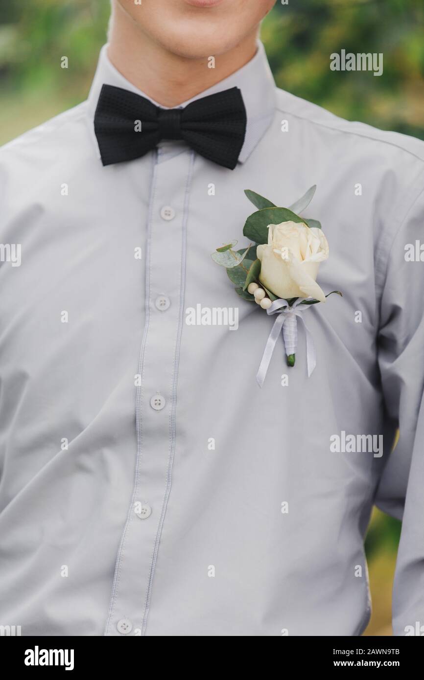 roses blanches fleurs dans le boutonnière, l'ami grooms est vêtu d'une  chemise grise et d'un noeud papillon. Jour de mariage. Tenue de la journée  Photo Stock - Alamy