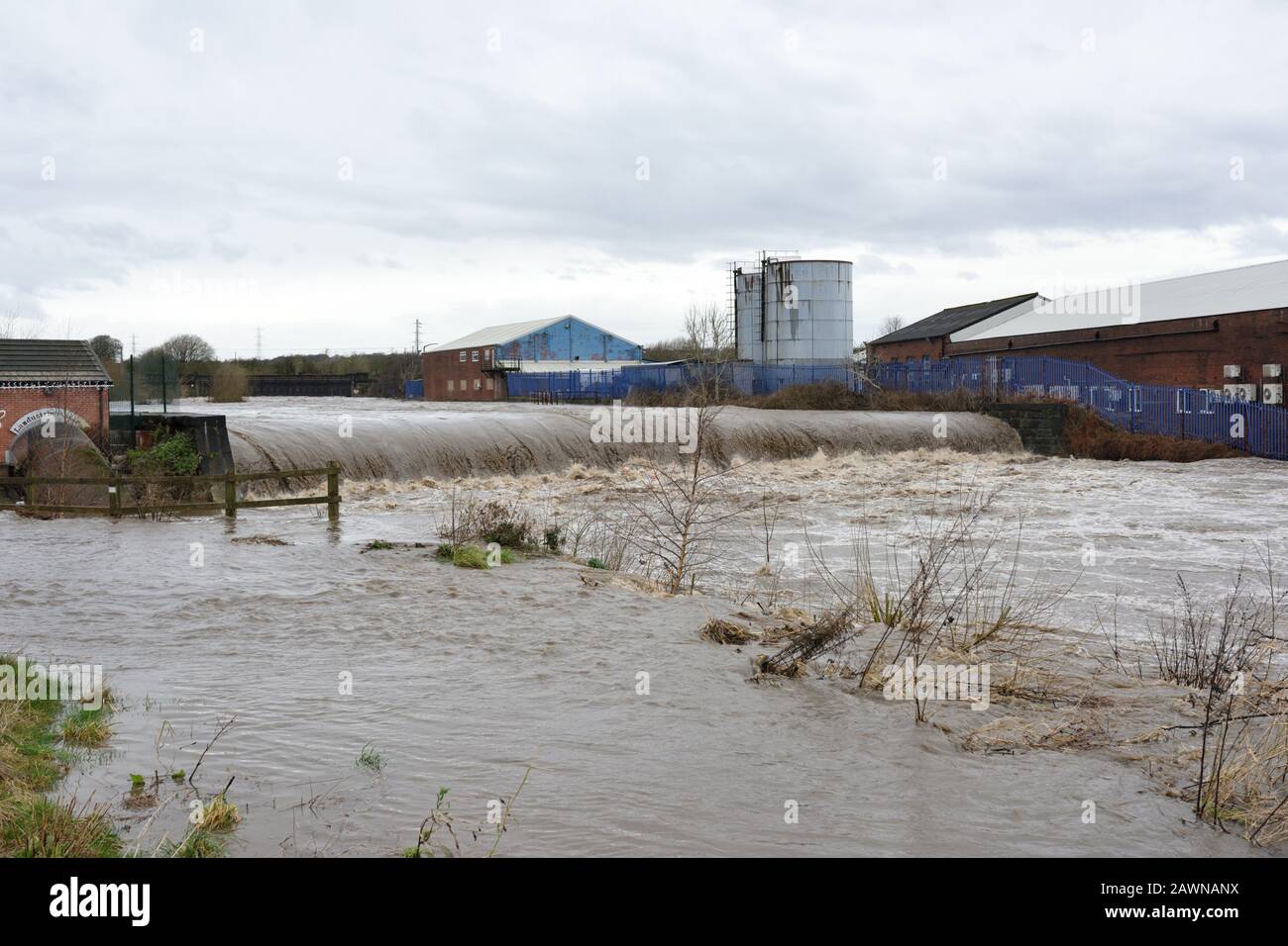 Storm ciara, River irwell éclate ses banques avec des bâtiments industriels en arrière-plan à radcliffe bury lancashire royaume-uni Banque D'Images