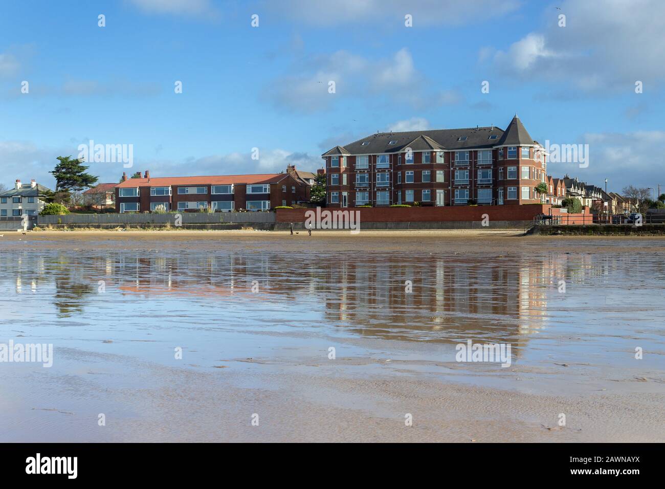 Bâtiments South Parade reflétés sur la plage, West Kirby Banque D'Images