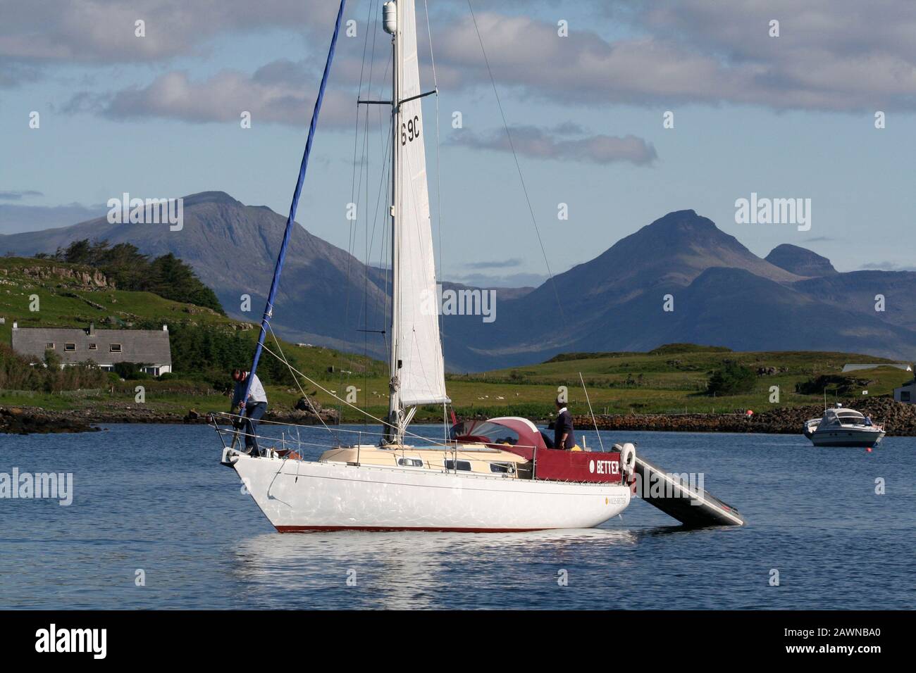 Yacht à voile sortant de Port Mor, Ile de Muck, avec Rum au loin, Inner Hebrides Banque D'Images
