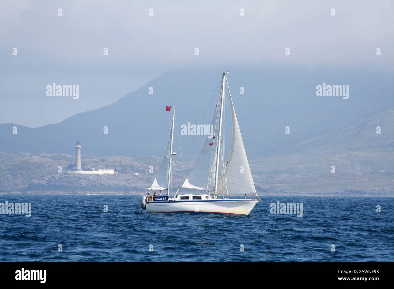 Yacht à voile arrondir le phare d'Ardnamurchan, Argyll, Ecosse Banque D'Images