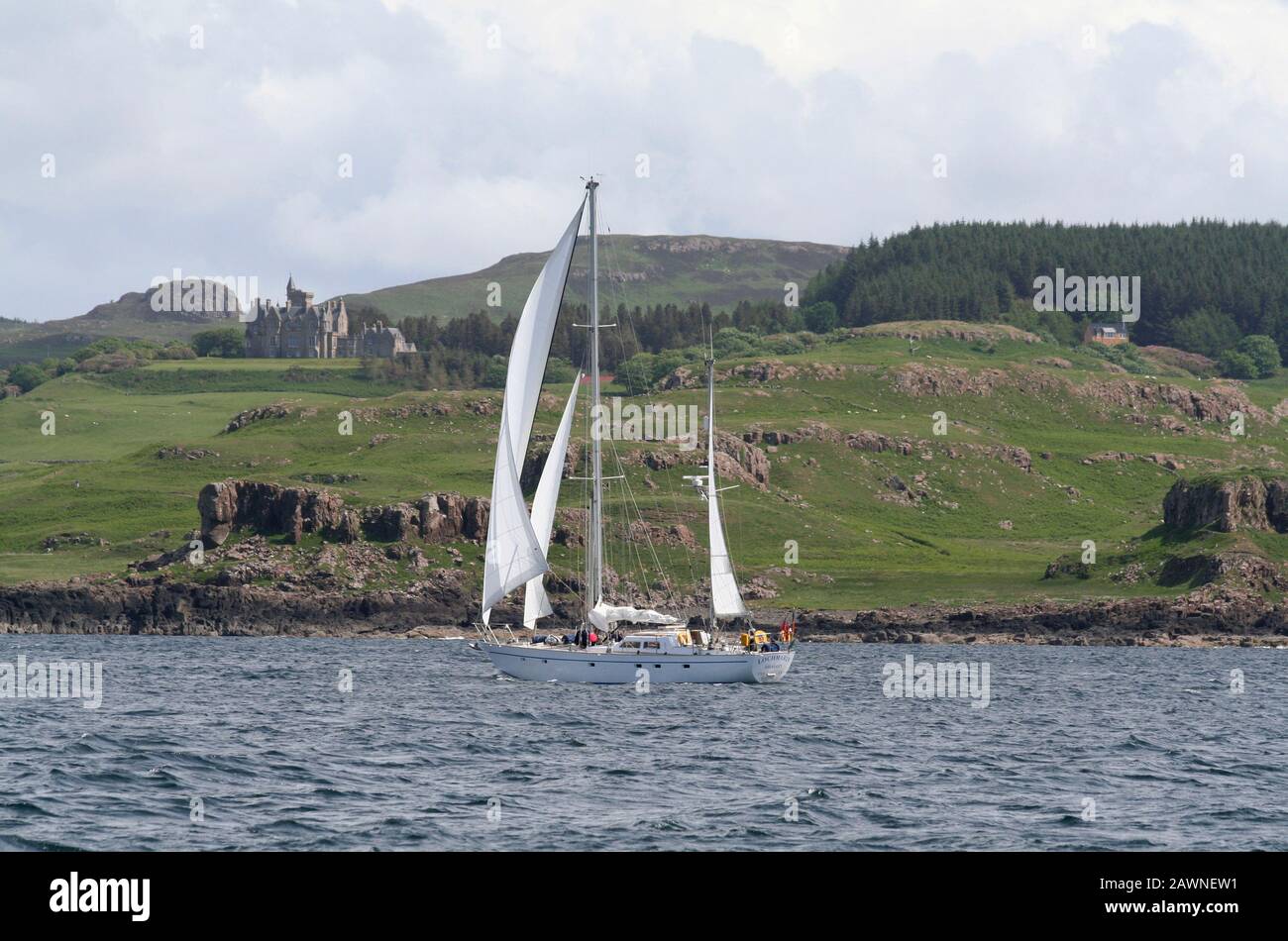 Yacht à voile en passant par le château de Glengorm, l'île de Mull, Inner Hebrides, Écosse Banque D'Images