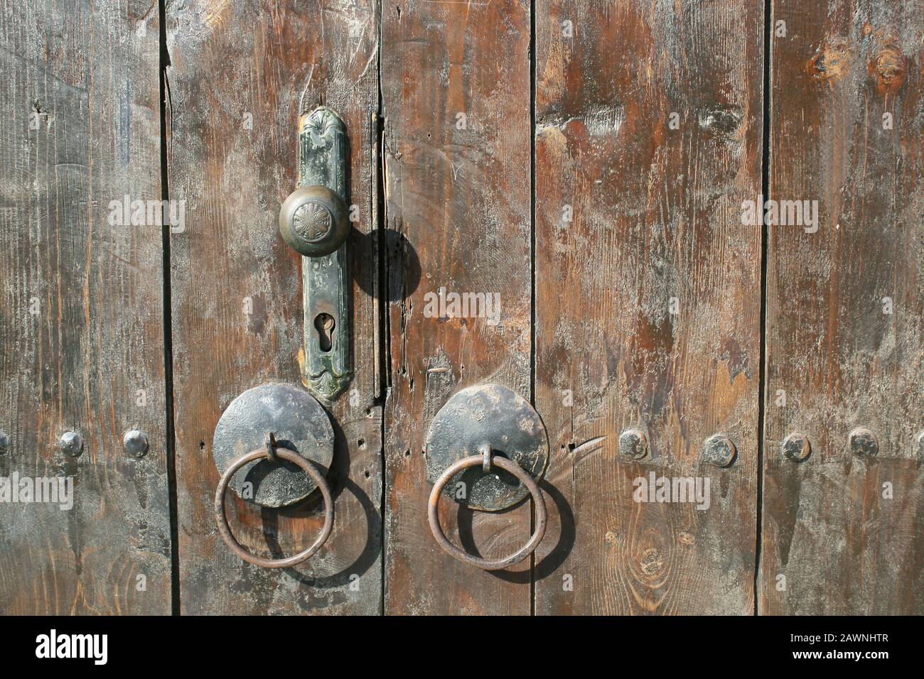 Ancienne porte en bois dérésonnée avec poignée de porte en fer sur une maison bulgare traditionnelle. Banque D'Images