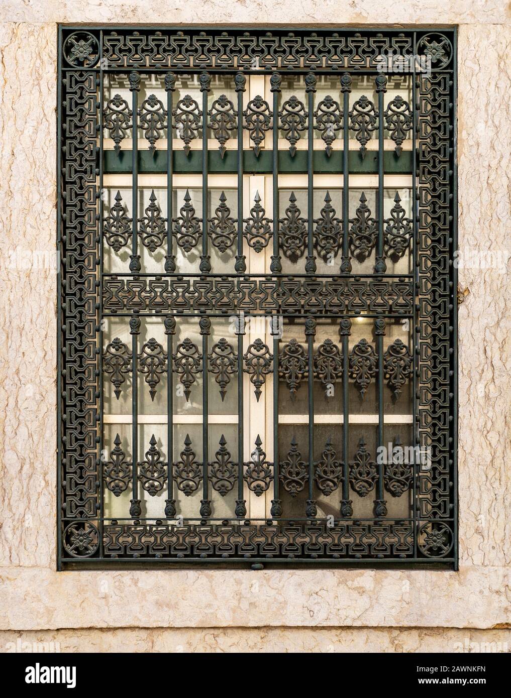 Détail d'une grille en fer vintage élaborée couvrant une fenêtre sur un vieux bâtiment dans le centre historique de Lisbonne, Portugal Banque D'Images