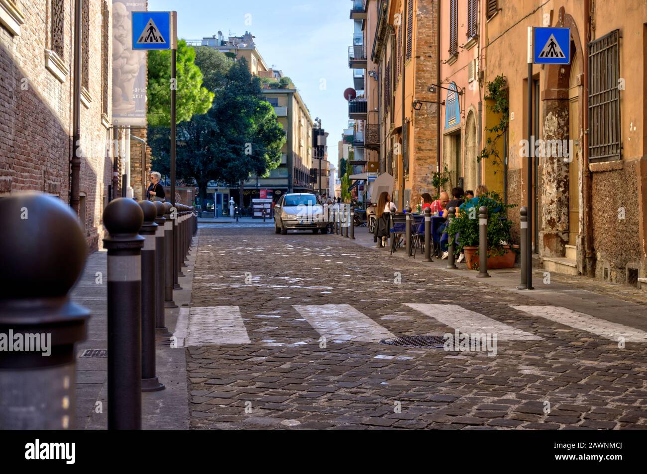 Rimini, Italie - 20 octobre 2019: Petit groupe de personnes mangent et boivent à l'extérieur d'un café dans l'arrière-rue. Banque D'Images